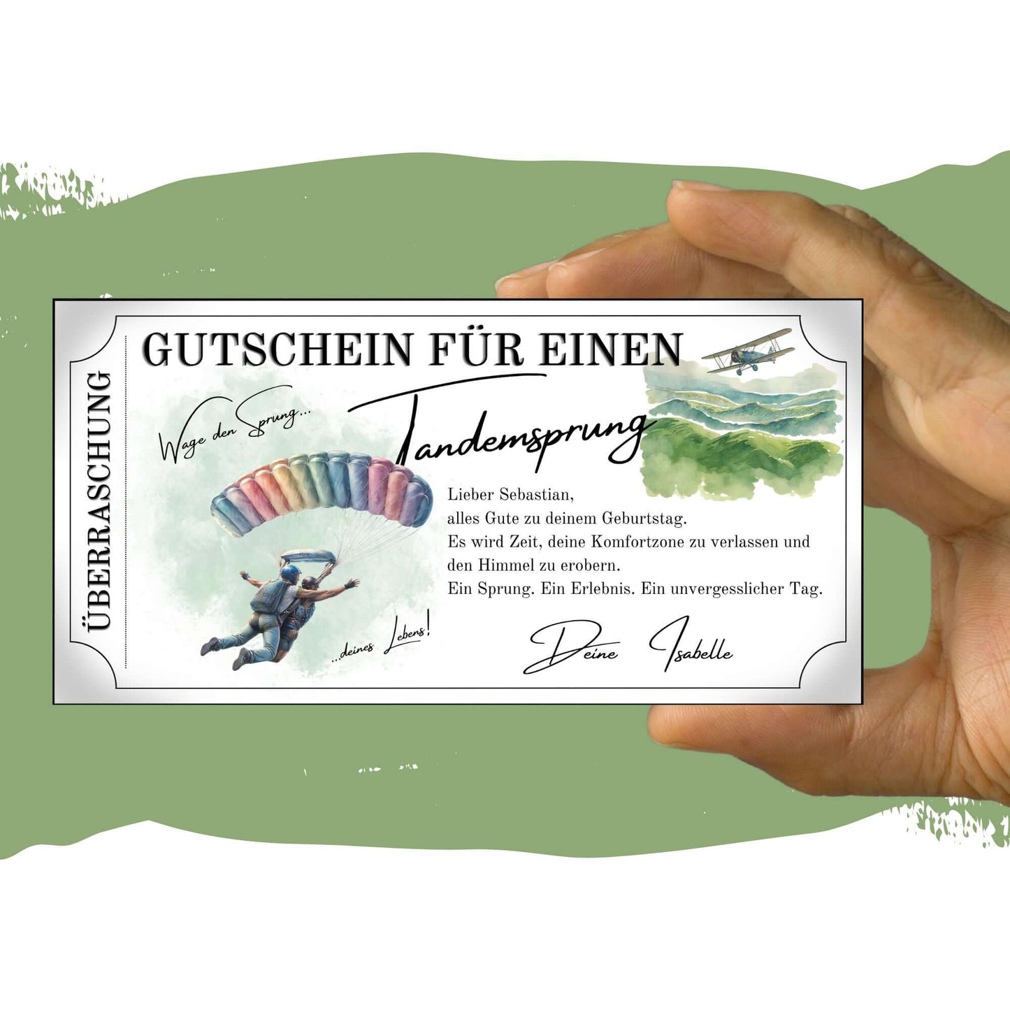 Hand hält einen Tandemsprung Gutschein mit persönlichen Glückwünschen und einem farbenfrohen Fallschirm-